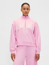 Buzo deportivo de color rosado con cuello alto y medio cierre frontal. Presenta el logo de la marca Gap 1969 bordado en el pecho junto a un emblema circular. Posee mangas largas con puños elásticos y un corte holgado.