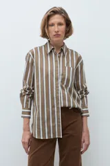 Camisa de corte clásico con estampado de rayas verticales en tonos khaki, blanco y azul. Presenta cuello camisero, cierre frontal con botones, bolsillo en el pecho y mangas largas con puños abotonados.