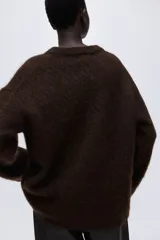 Buzo de corte oversized confeccionado en punto suave con mezcla de lana y mohair. Presenta diseño de hombros caídos, cuello redondo y terminaciones acanaladas en cuello, puños y ruedo.