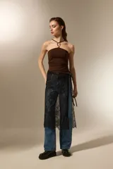 Falda midi negra de poliamida, con diseño de encaje floral y anudado en la cintura.