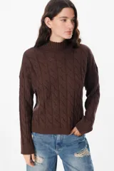 Sweater negro de punto trenzado con cuello alto.