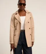 Buzo femenino modelo trench coat, confeccionado en poliéster con detalles acetinados, cuello solapa, cierre delantero con botones matizados y lazo con faixa pespontada.