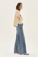 Sweater de tejido de punto color crudo, con escote redondo y mangas largas con puños acanalados. Presenta un calce cómodo y holgado.