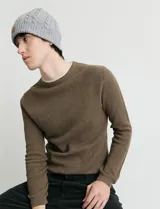 Sweater de punto con textura waffle, color negro, de corte clásico con cuello redondo y mangas largas con puños ajustados.