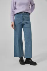 Pantalón de jean negro, de corte ancho y tiro alto, con ruedo deshilachado.