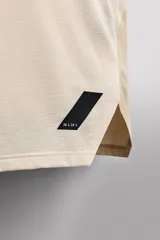 Musculosa deportiva color naranja con cuello redondo, sisas amplias y detalle de logo en el frente.