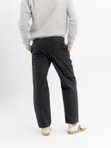 Pantalón estilo carpintero de corte regular y tiro medio, confeccionado en algodón resistente. Presenta bolsillos laterales, traseros y utilitarios, con cierre de botón y cremallera y terminación de pierna recta.