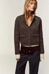 Chaqueta de punto con textura jaspeada, cuello solapa y manga larga. Presenta bolsillos delanteros de plastrón con solapa y cierre frontal con botones forrados a tono.