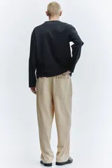 Pantalón en punto de mezcla de algodón, color beige, de corte regular y piernas rectas. Cuenta con cintura elástica con cordón ajustable, bolsillos laterales al bies y bolsillos traseros de parche.