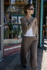 Chaqueta de punto de cuello redondo y manga larga, con cierre frontal de botones y acabados en rib.