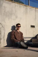 Buzo marrón de algodón con cuello redondo y logo bordado en el pecho.