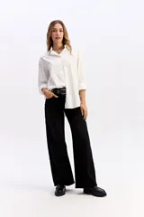 Camisa de corte clásico y líneas limpias, confeccionada en algodón, con cuello camisero, cierre frontal de botones y mangas largas con puños.