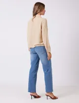 Camisa de crepe color beige con cuello clásico, cierre frontal con botones y dos bolsillos aplicados en el pecho.