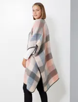 Ruana de tejido soft, marca Barrington, con diseño a cuadros grandes en tonos mostaza, gris oscuro y blanco. Presenta terminación en zig zag con lana en los bordes.