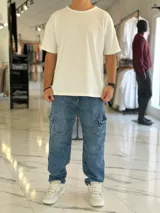 Pantalón cargo de jean azul con múltiples bolsillos en los laterales y diseño holgado.