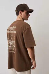Remera oversize azul con mangas anchas, cuello redondo con textura tejida y estampa frontal pequeña a la altura del pecho.