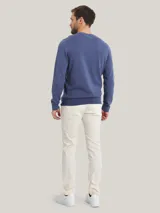 Pantalón chino color crema de corte slim fit, confeccionado en algodón pima elástico.
