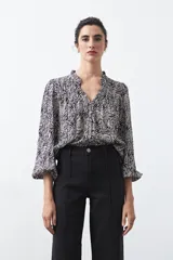 Jean wide leg de color negro, con costuras frontales verticales que estilizan la silueta y cierre frontal con botón metálico.