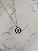 Collar de acero quirúrgico con dije circular de ojo turco esmaltado en tonos verde oscuro, blanco y turquesa.