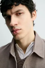 Sobrecamisa de corte regular fit en tejido elástico y transpirable, con cuello solapa, cierre frontal mediante botones a presión y bolsillo de plastrón en el pecho. Presenta mangas largas con puños abotonados y bajo con aberturas laterales.