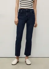 Jeans de corte flare y tiro alto, color azul oscuro, con diseño crop y terminación deshilachada en los tobillos. Cuenta con cierre de cremallera y botón, trabillas para cinturón y cinco bolsillos.