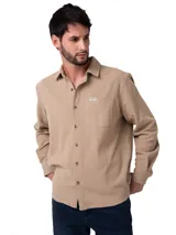 Camisa de manga larga Caterpillar confeccionada en tejido waffle de algodón color beige. Presenta cuello camisero, cierre frontal con botones perlados, puños abotonados y un bolsillo en el pecho con etiqueta de la marca.