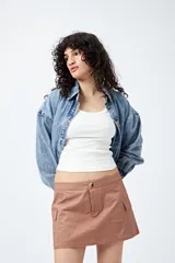 Minifalda color beige estilo cargo, de tiro bajo y corte recto, con bolsillos laterales.