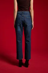 Pantalón jean negro de tiro medio y corte flare, con bolsillos laterales y traseros.