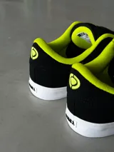 Championes CIRCA AL 50 PRO negros con detalles en amarillo flúor.