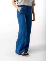 Pantalón de lino de corte holgado y tiro ajustable, con cintura elástica y cordón. Presenta bolsillos laterales y un bolsillo trasero.