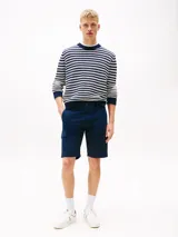 Pantalón corto tipo cargo de corte slim, confeccionado en algodón elástico. Presenta cierre de cremallera con botón, bolsillos laterales tipo cargo, bolsillos laterales ribeteados y bolsillos traseros de ojal. Incluye parche con logo de Tommy Jeans en la parte trasera.