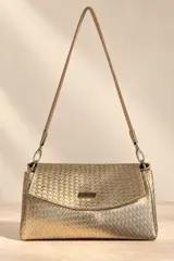 Cartera de mano Pecari modelo Bea, confeccionada en cuero vacuno con textura tejida color dorado. Presenta solapa frontal con broche imantado y placa metálica con el logo de la marca, además de una correa larga para el hombro.