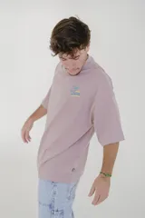 Remera color crema de corte holgado con cuello redondo y mangas cortas. Estampado en el pecho con la inscripción "Pulau Cold Winter" en letras azules y amarillas.