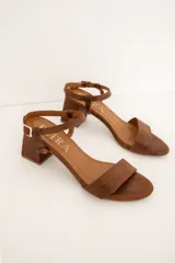 Sandalias de cuero marrón con tira frontal, tira ajustable al tobillo con hebilla y taco bloque de madera.