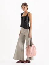 Bolso tipo hobo confeccionado en cuero vacuno con efecto rugoso, de color negro, con manija larga de hombro y ribetes en cuero liso. Incluye un llavero colgante de cuero con la marca grabada.