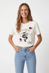 Remera de manga corta color blanco con estampa frontal ilustrada que incluye una serpiente, rosas y la leyenda "All I Ever Wanted".