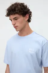 Remera marrón de manga corta con calce relajado, confeccionada en jersey de algodón pesado. Presenta una pequeña estampa con texto en el pecho y un diseño estampado en la espalda.