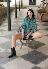 Camisa de manga larga con diseño abullonado, confeccionada en tela bordada con motivos florales. Presenta cierre frontal con botones y puños elásticos.