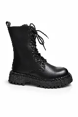 Borcegos de caña media color negro, con cierre lateral, cordones frontales y suela track de goma dentada.