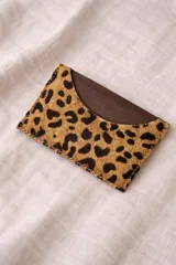 Tarjetero de cuero con diseño animal print en el frente y cuero liso marrón oscuro en la parte posterior, con compartimentos para tarjetas en ambos lados.
