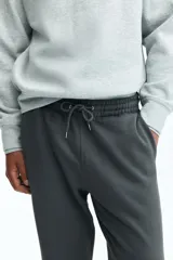Pantalón deportivo gris oscuro de felpa de mezcla de algodón, con elástico y cordón ajustable en la cintura, bolsillos laterales y puños acanalados.