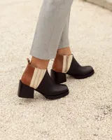 Botines Chelsea de cuero, color negro, con detalles en cuero marrón texturizado (tipo cocodrilo) y paneles laterales en color beige claro. Tienen un taco ancho y cuadrado, y cierre de cremallera lateral en color beige.