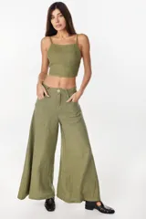 Pantalón de lino verde militar, de tiro alto y corte amplio con botamanga ancha. Cuenta con bolsillos delanteros aplicados y cierre frontal con botón y bragueta.