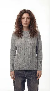 Sweater de punto con textura de ochos verticales, cuello redondo, mangas largas con puños acanalados y silueta relajada.