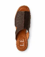 Sandalias planas de cuero marrón oscuro, estilo mule con empeine cubierto y diseño abierto en los laterales.