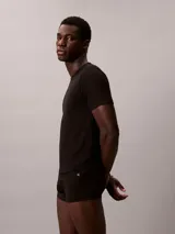 Pack de tres remeras de cuello redondo y manga corta, confeccionadas en una mezcla de algodón, poliéster y elastano. Incluye una remera roja, una blanca y una negra, todas con el logo de Calvin Klein bordado en el bajo.