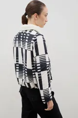 Campera con estampado de bosque en tonos azules, cuello de sherpa en color crema y cierre frontal con cremallera. Cuenta con elástico ajustable en la cintura.