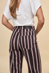 Jean barrel de tiro alto con silueta amplia y piernas ligeramente curvas que se afinan hacia el tobillo. Diseño con estampa de rayas verticales, bolsillos delanteros y traseros, cierre con botón y cremallera.
