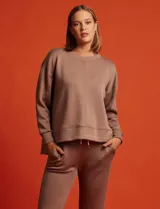 Buzo marrón de tejido elastizado, con pespunte central en la parte delantera y tajos laterales.