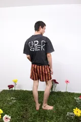 Remera gris de algodón con efecto acid wash, cuello redondo y mangas cortas. Presenta un pequeño logo estampado en el pecho y un estampado más grande en la espalda.